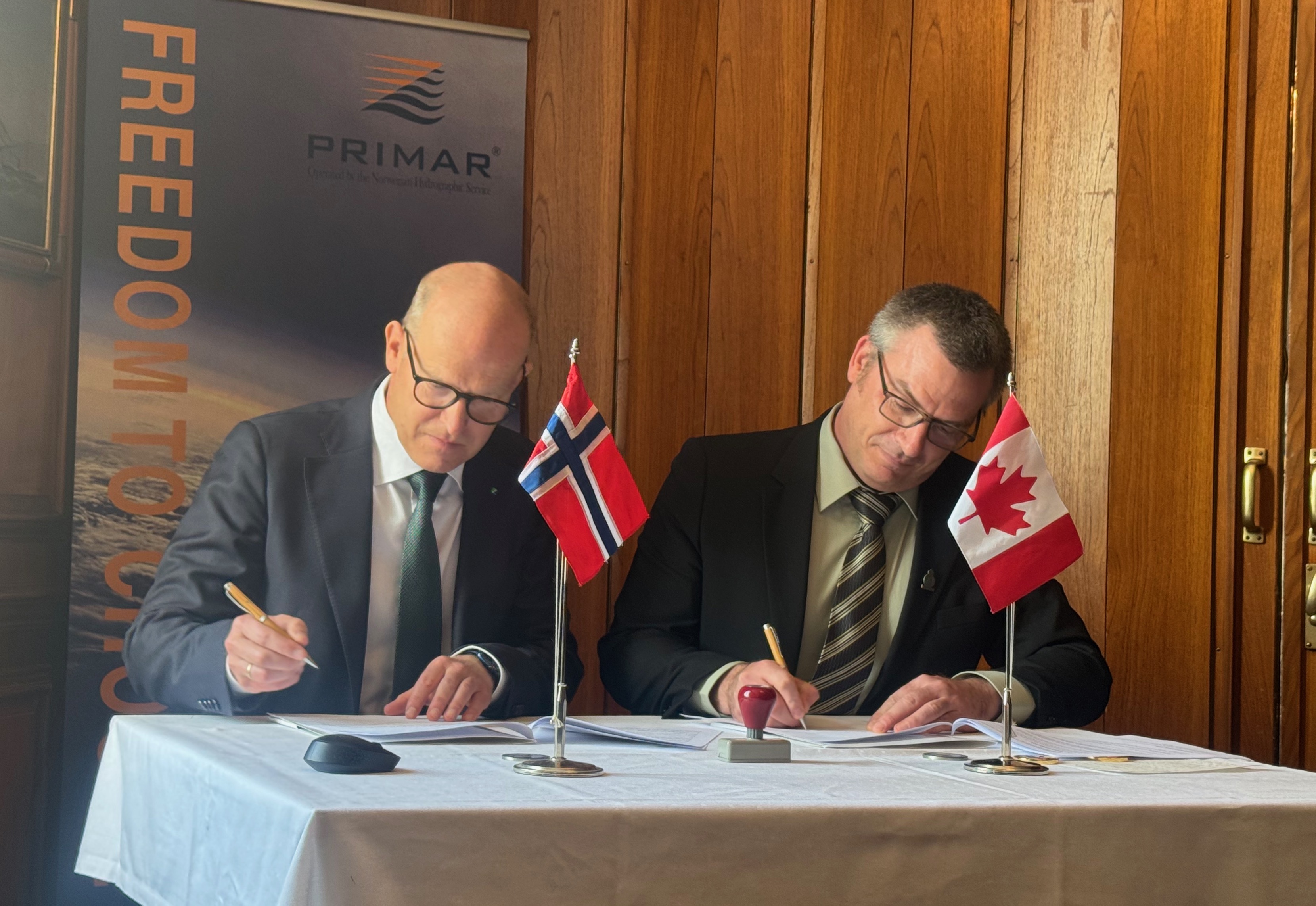 Kartverksdirektør Johnny Welle og Louis Maltais fra CHS signerer PRIMAR-medlemskapet. 